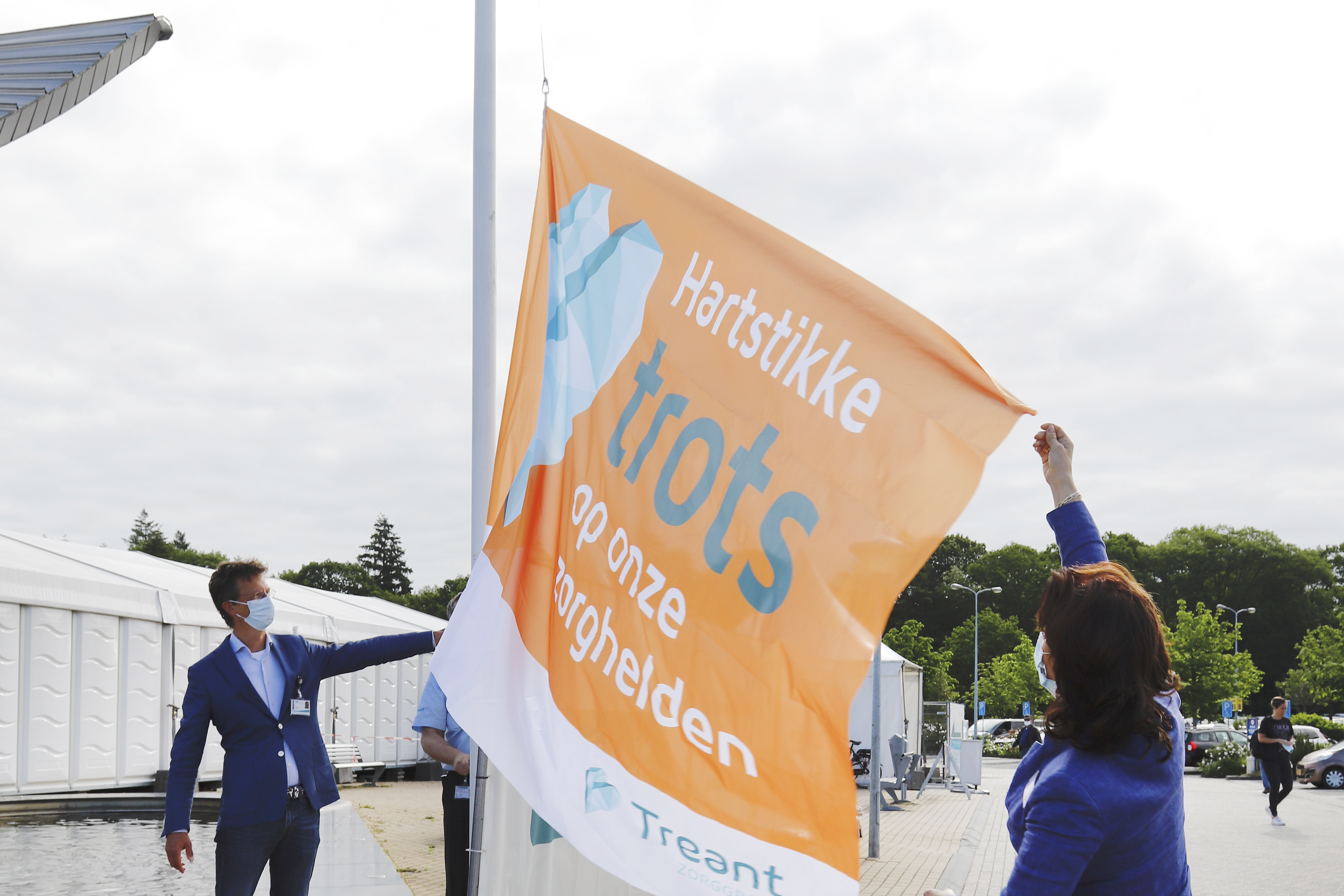 Bestuursvoorzitter Paula Nelissen en chirurg Frank Kroezen hijsen de vlag bij ziekenhuislocatie Scheper in Emmen. Foto: Bianca Verhoef Fotografie
