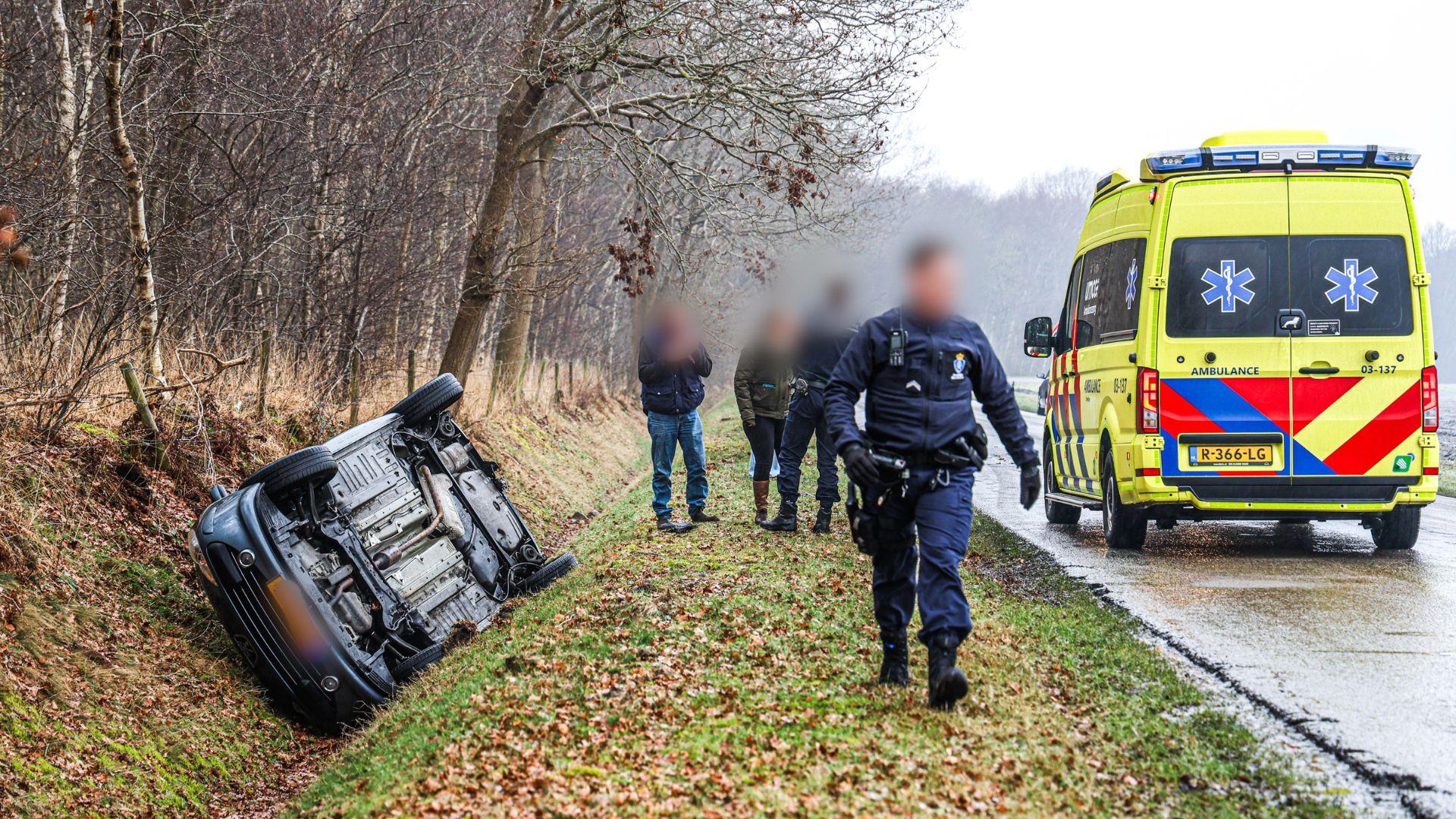 Auto op de kop in greppel door ijzel in Klazienaveen