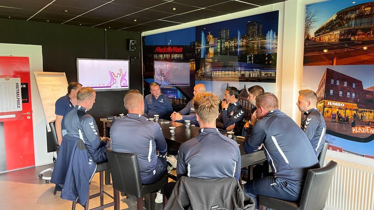 Acht jeugdtrainers van FC Emmen luisteren naar het verhaal van Smeenk